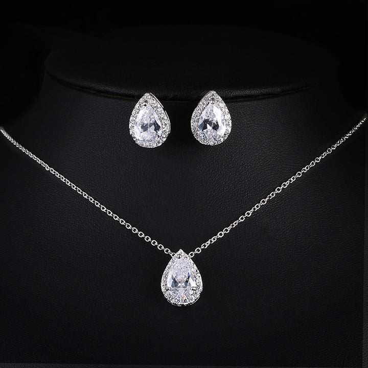 Jewelry set with teardrop-shaped necklace, pendant, and earrings on a black background
