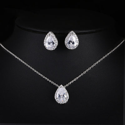 Jewelry set with teardrop-shaped necklace, pendant, and earrings on a black background