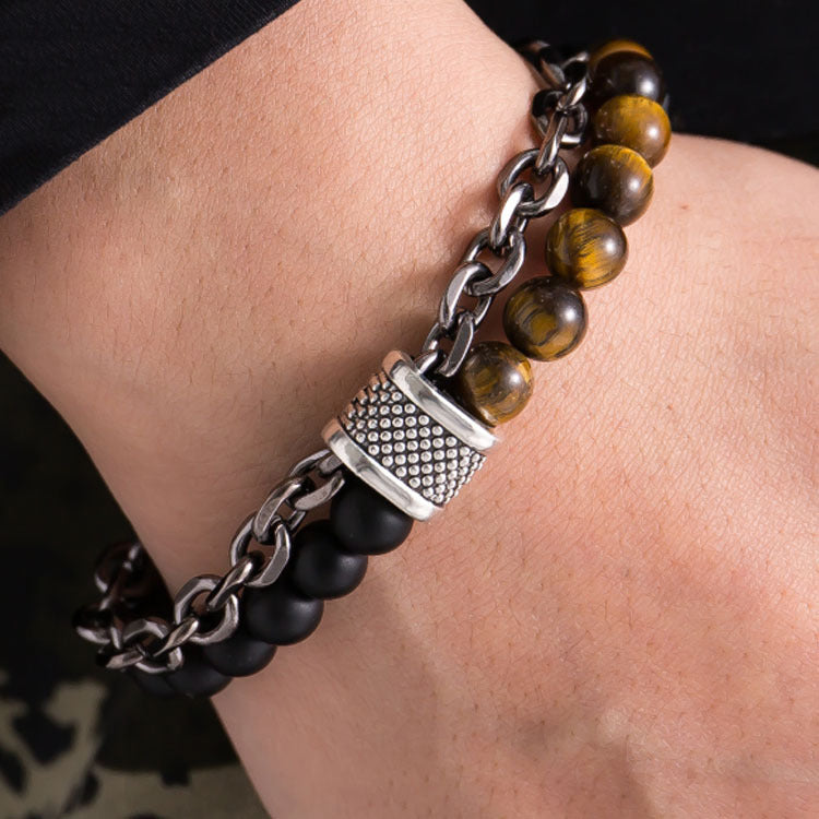 Bracelet with black and brown beads and silver chain on wrist