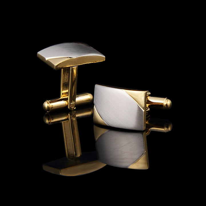 Gold and silver cufflinks on a black background