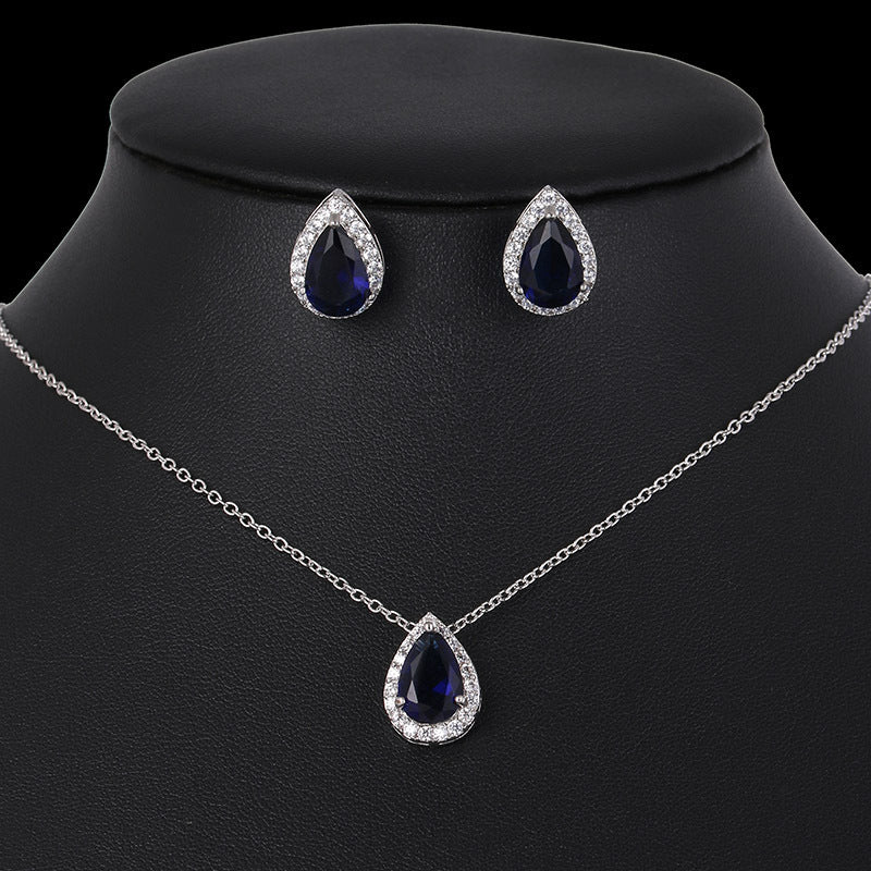 Teardrop-shaped jewelry set with necklace and earrings on a black mannequin bust.