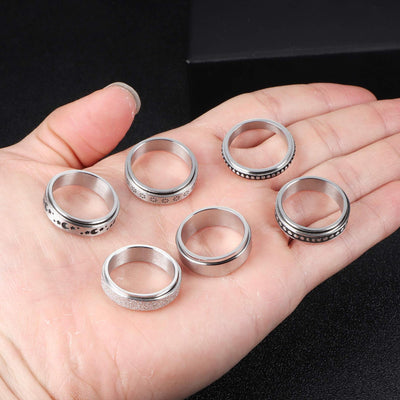 Set of silver rings on a hand against a black background