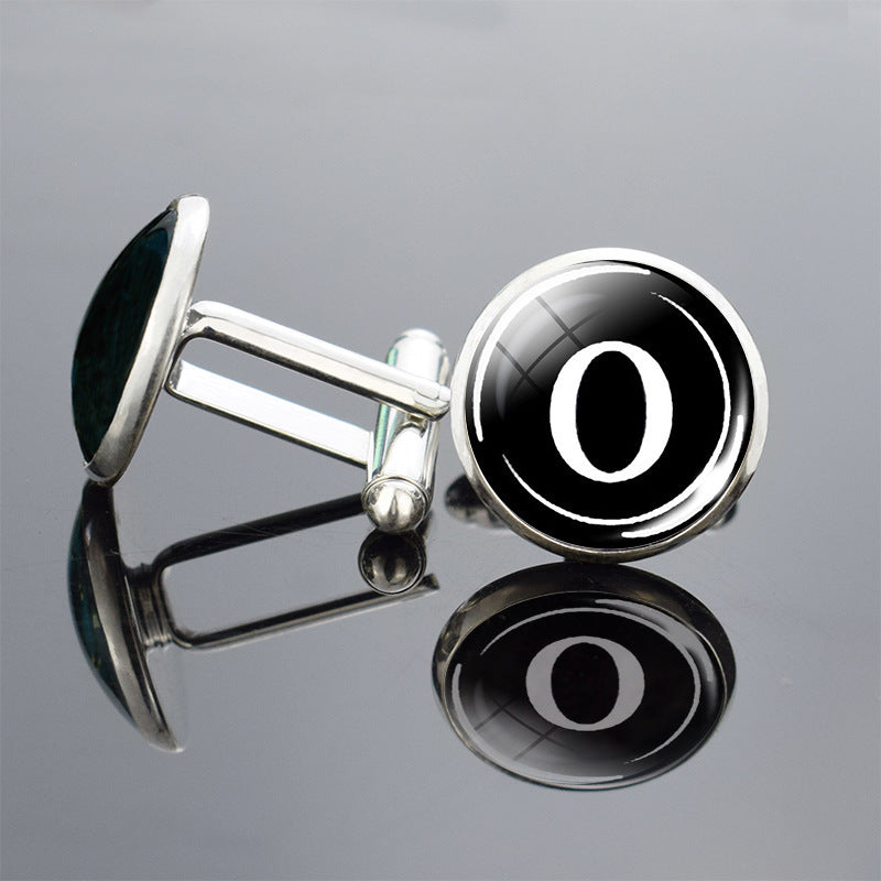 Cufflinks with a black and silver design on a reflective surface