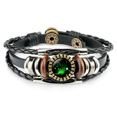 Braided black leather bracelet with metallic and wooden beads, featuring a central circular green emblem with a glowing, mystical design.