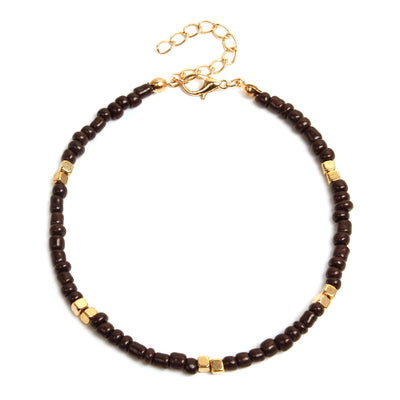 anklet  with brown beads and gold accents on a white background
