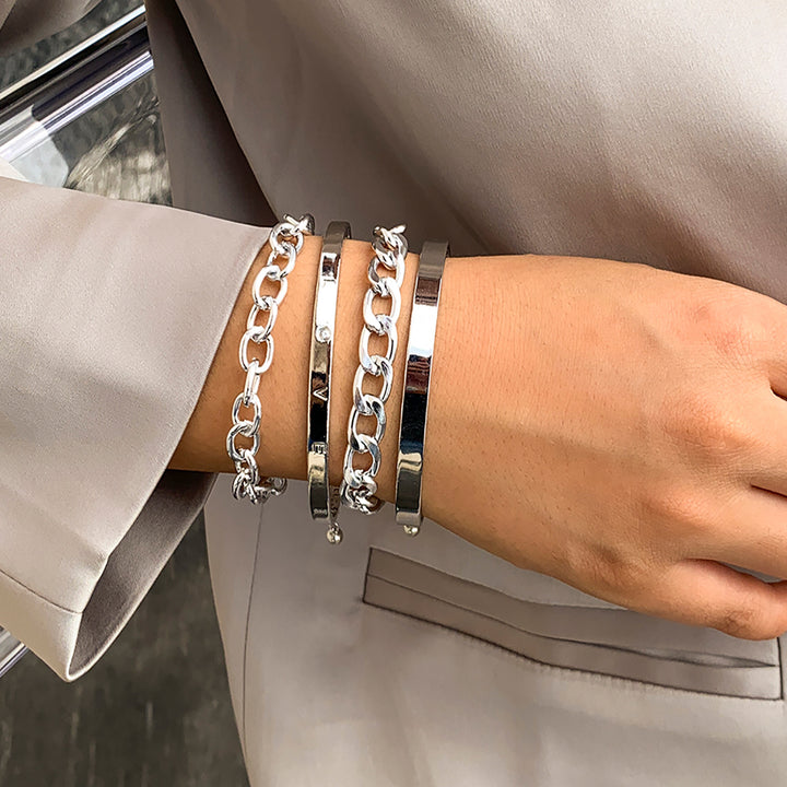 four Silver chain bracelets on a person&