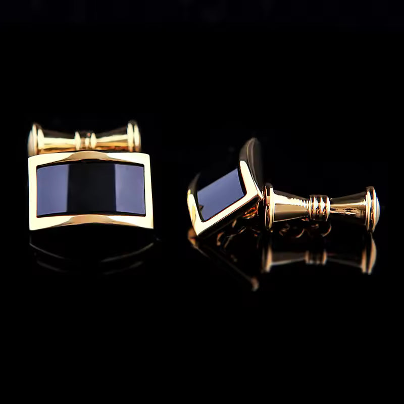 Gold cufflinks with blue stones on a black background
