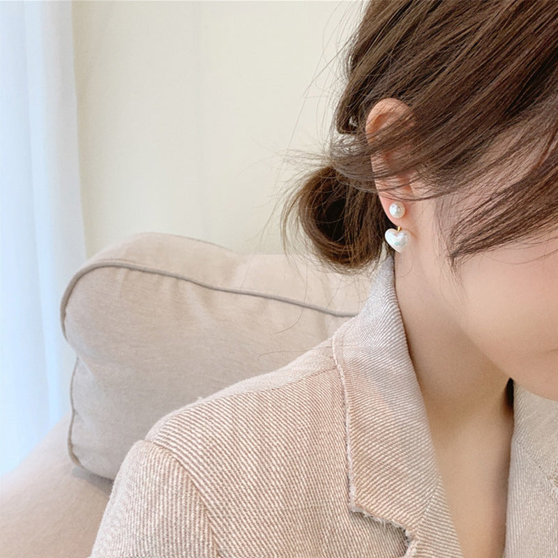 Woman wearing pearl earrings with a neutral background