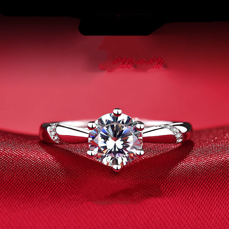 Silver ring with a large diamond on a red fabric background
