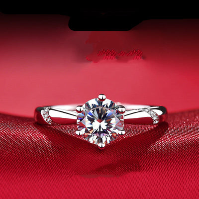 Silver ring with a large diamond on a red fabric background