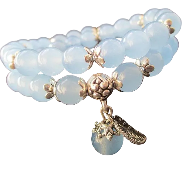 Blue beaded bracelet with gold charms on a white background