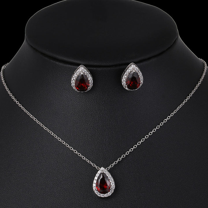 Jewelry set with teardrop-shaped red gemstones on a black mannequin.
