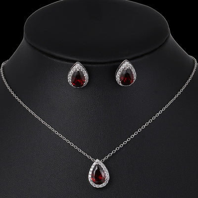 Jewelry set with teardrop-shaped red gemstones on a black mannequin.