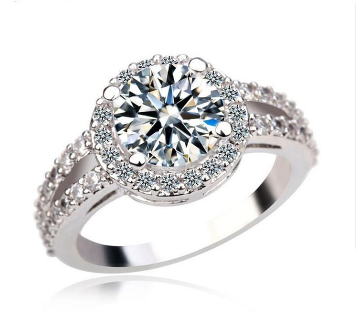 Silver ring with a large crystal and smaller crystals on a white background