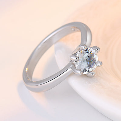 Silver ring with a clear gemstone on a light background