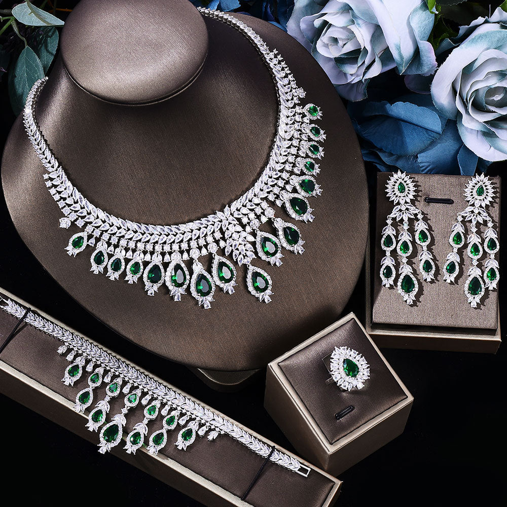 green stone Bridal Jewelry set including necklace, earrings, and ring with green gemstones on a dark surface.
