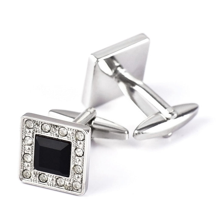 Silver square cufflinks with black center and clear stones on a white background