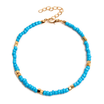 Turquoise beaded anklet with gold accents on a white background