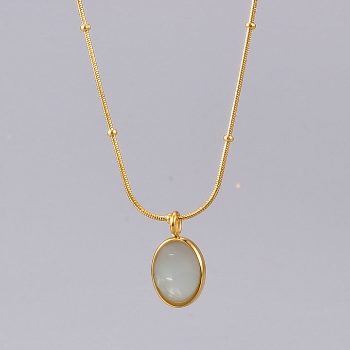 Gold necklace with a pendant on a gray background