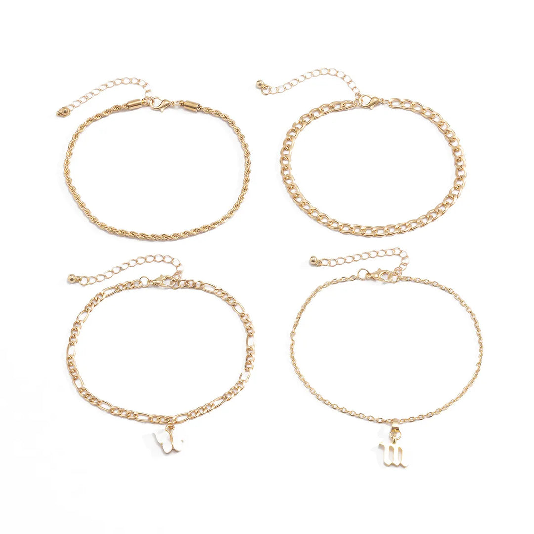 Set of four gold chain Anklets with letter charms on a white background