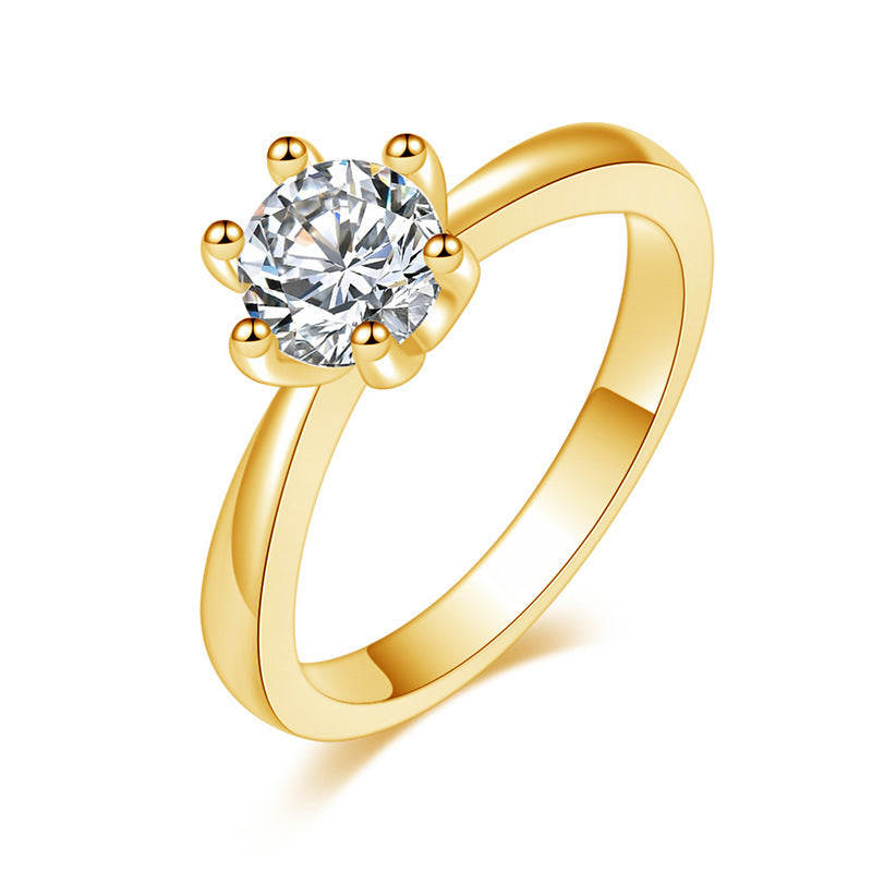 Gold ring with a clear gemstone on a white background