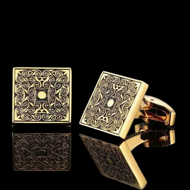 Gold square cufflinks with intricate patterns on a gray background