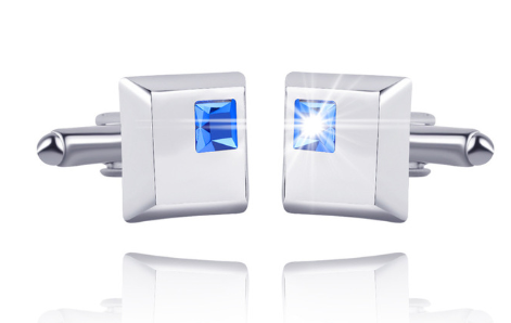 Pair of silver cufflinks with blue gemstones on a white background
