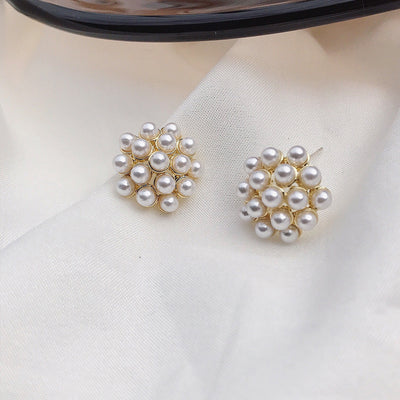 Pair of pearl earrings on a light fabric background
