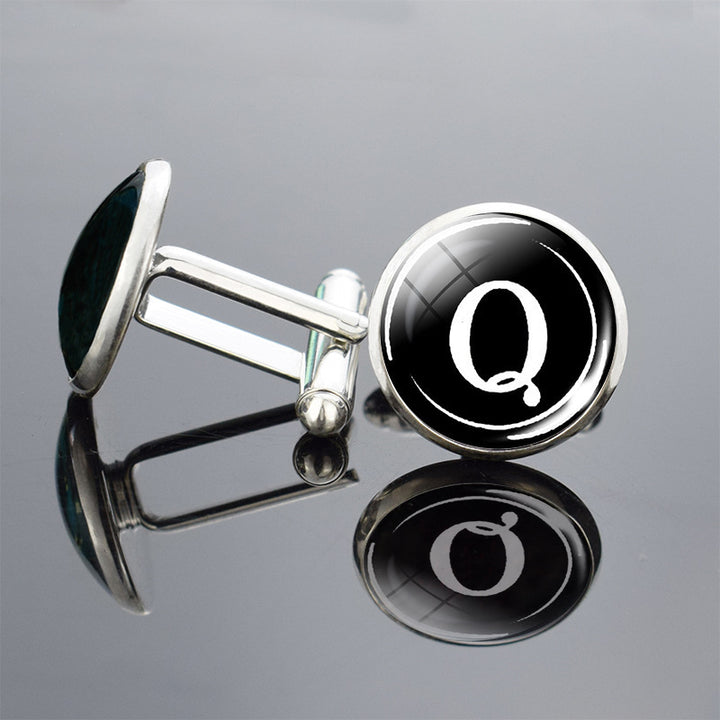 Cufflinks with a black and silver design on a reflective surface