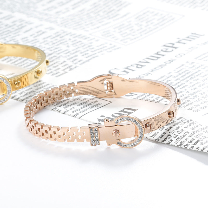 Rose gold bracelet with a clasp design on a newspaper background