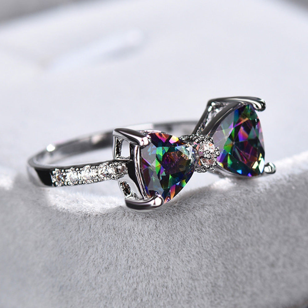 Ring with heart-shaped gemstones on a light gray background