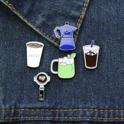 Set of coffee-themed pins on a denim background