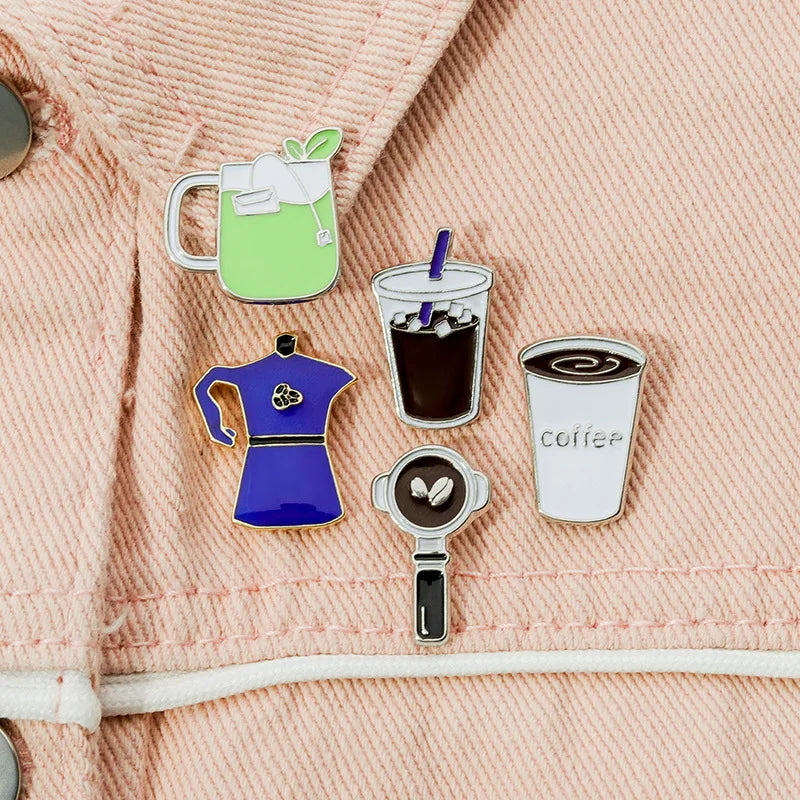 Set of coffee-themed pins on a textured fabric background