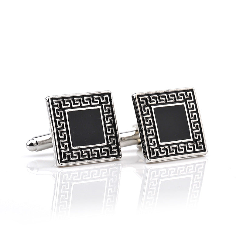 Pair of square cufflinks with black center and silver border on a white background