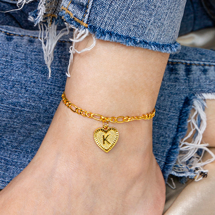 Gold anklet with a heart-shaped charm on a person&