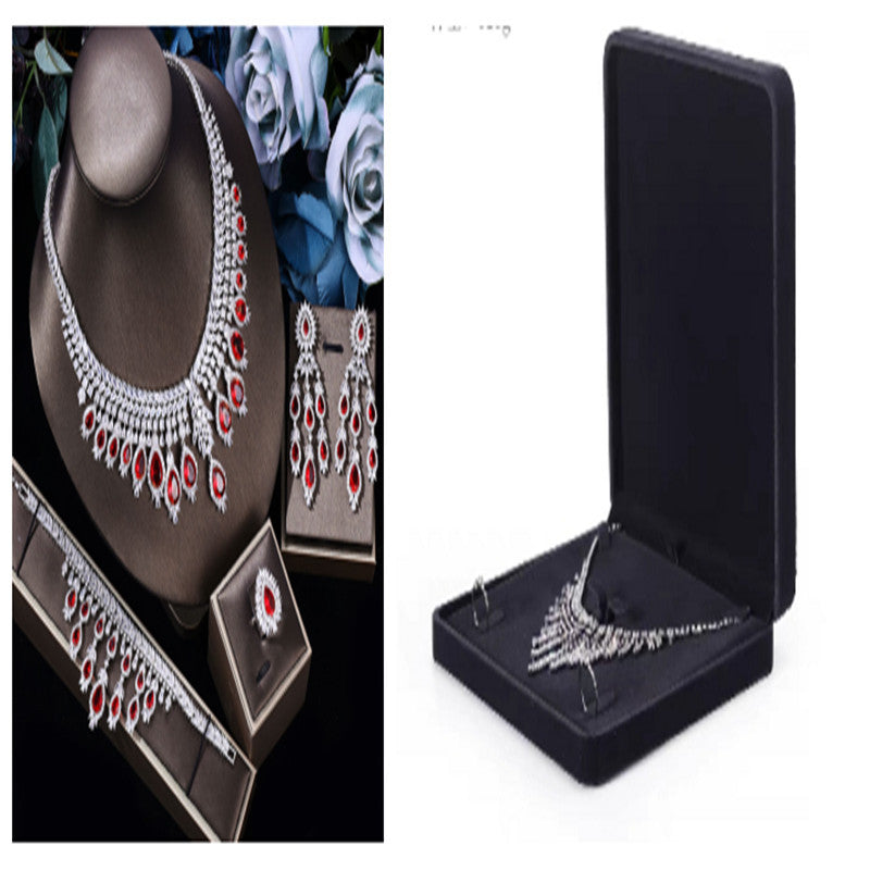 Jewelry set with necklace, earrings, and brooch on a stand and in a box.