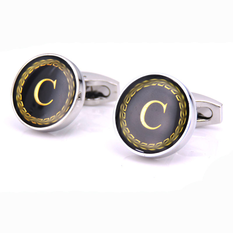 Cufflinks with black and gold design on a white background