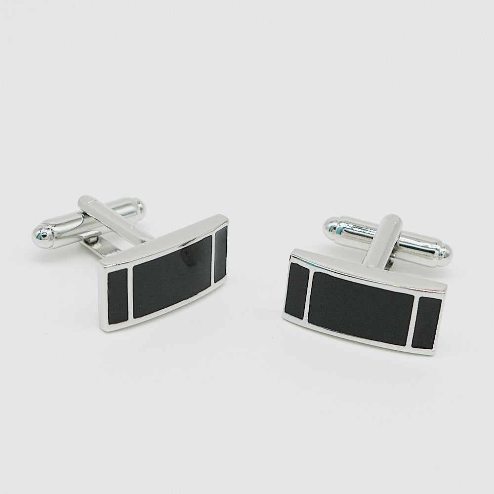 Pair of silver cufflinks with black rectangular stones on a light gray background
