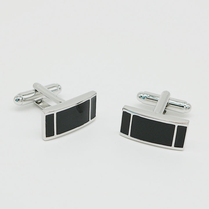 Pair of silver cufflinks with black rectangular stones on a light gray background