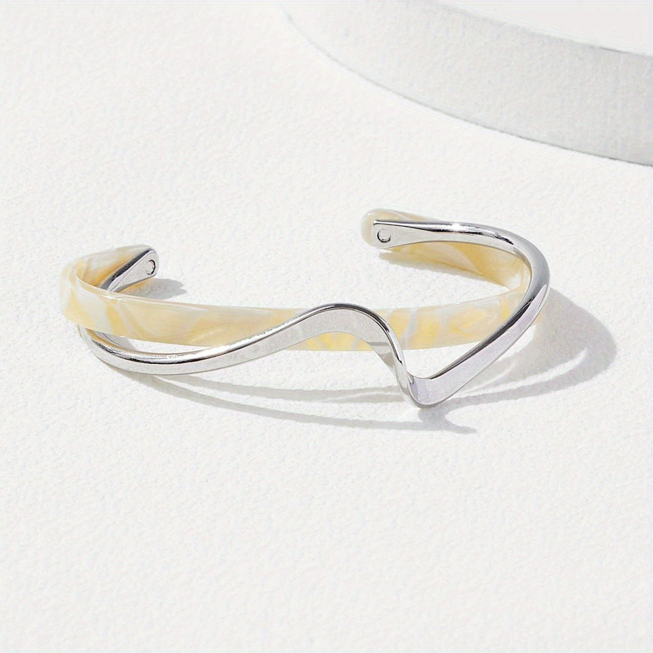 Silver and beige bangle on a white background