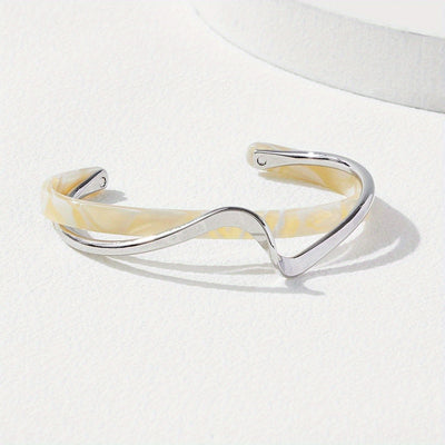 Silver and beige bangle on a white background
