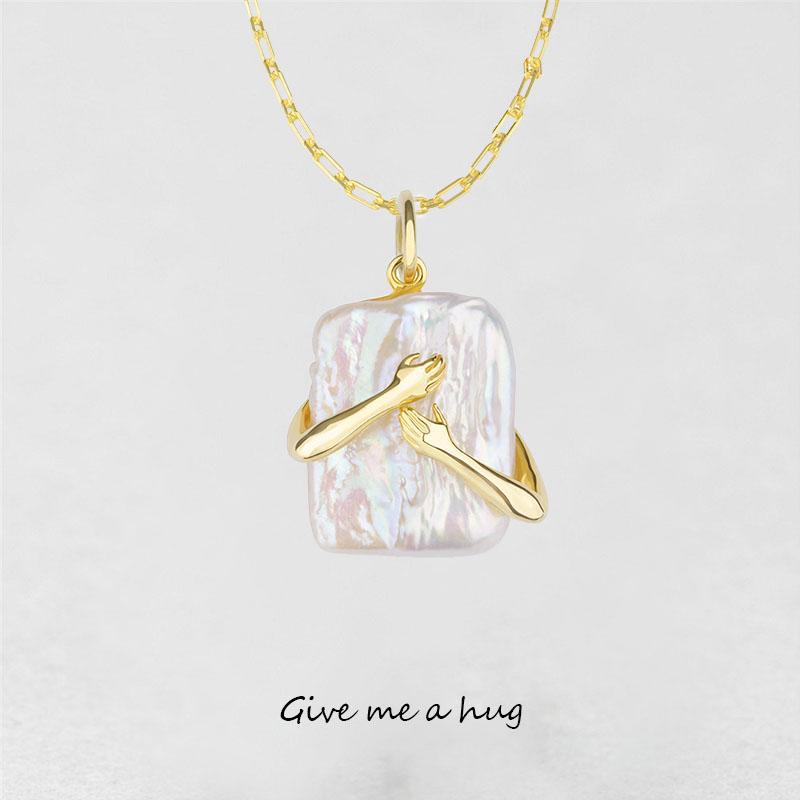 Gold necklace with a pendant on a light gray background