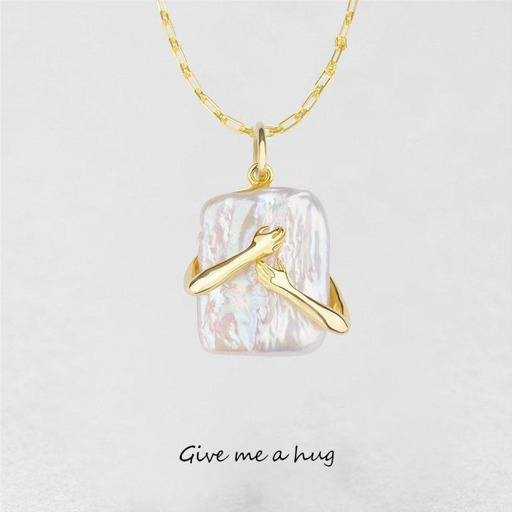 Gold necklace with a pendant on a light gray background