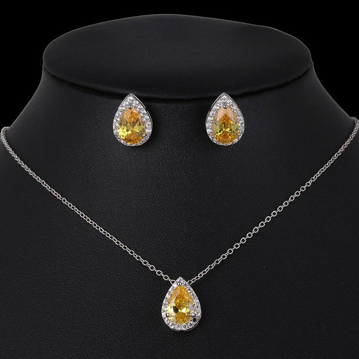 Jewelry set with teardrop-shaped yellow gemstones on a black background