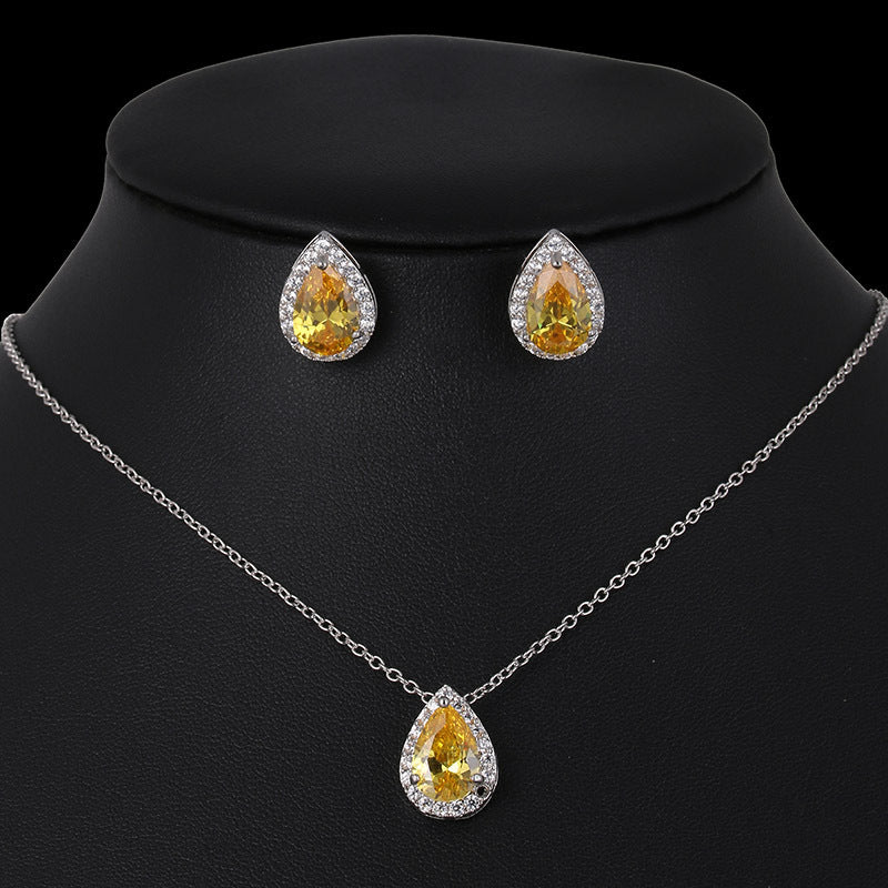 Jewelry set with teardrop-shaped yellow gemstones on a black background