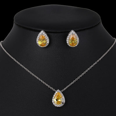 Jewelry set with teardrop-shaped yellow gemstones on a black background