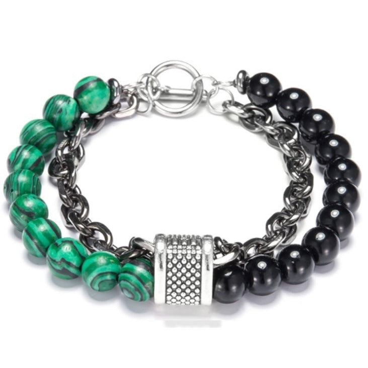Bracelet with green and black beads and silver clasp on a white background