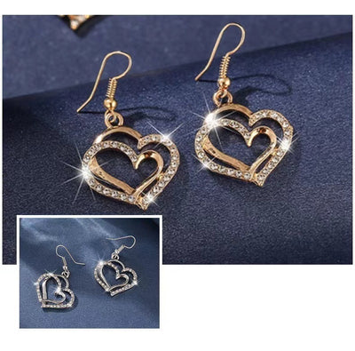 Heart-shaped earrings with gold and silver finishes on a dark blue background