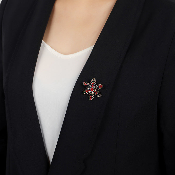 Black blazer with a decorative brooch on a plain background