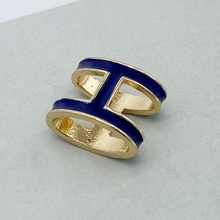 Gold ring with blue enamel on a light gray background